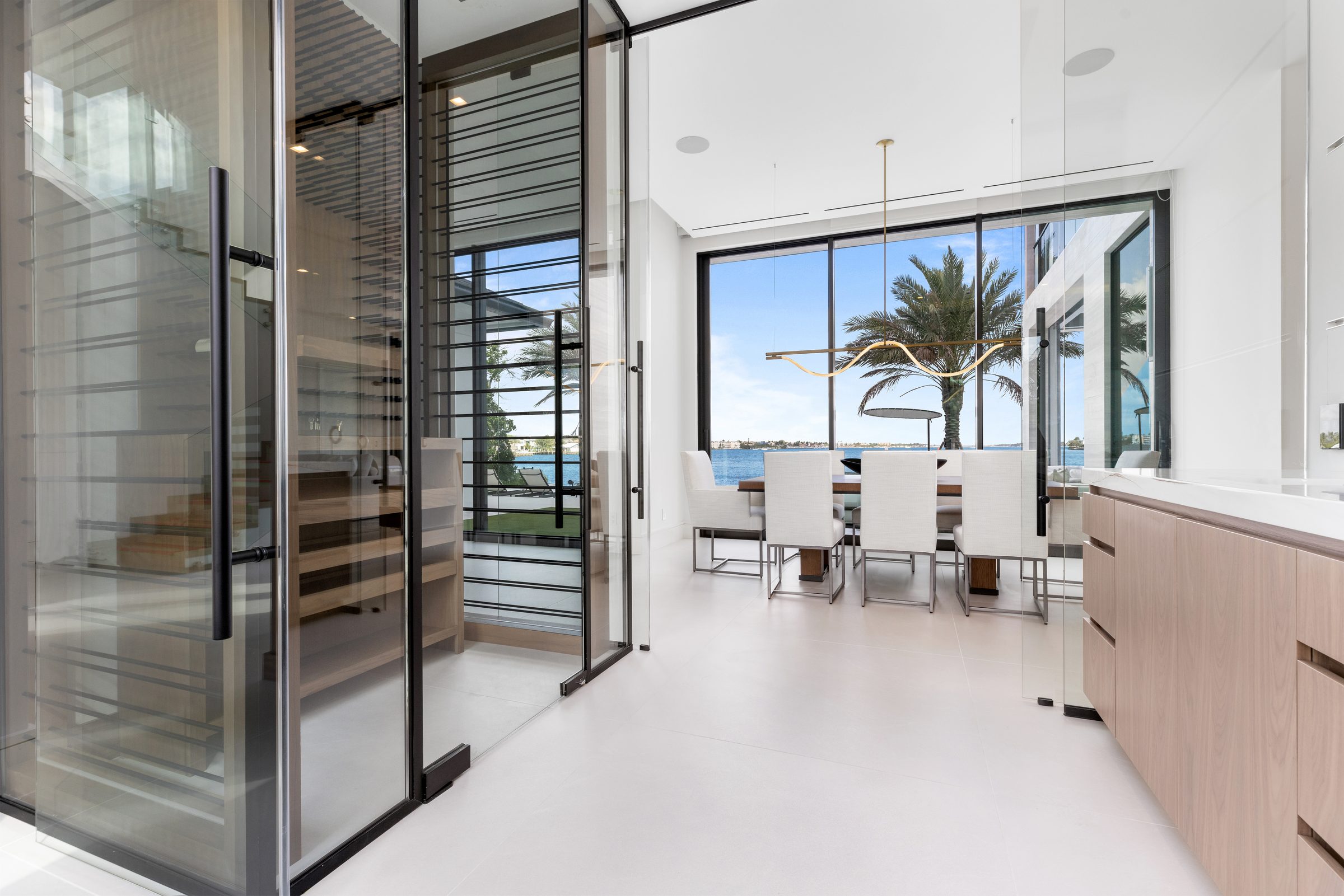 Glass-walled wine room in Ocean Ridge — built by Varga Homes